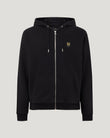 Close-up of black Belstaff full zip hoodie showing silver zipper, hood cords, and chest logo patch