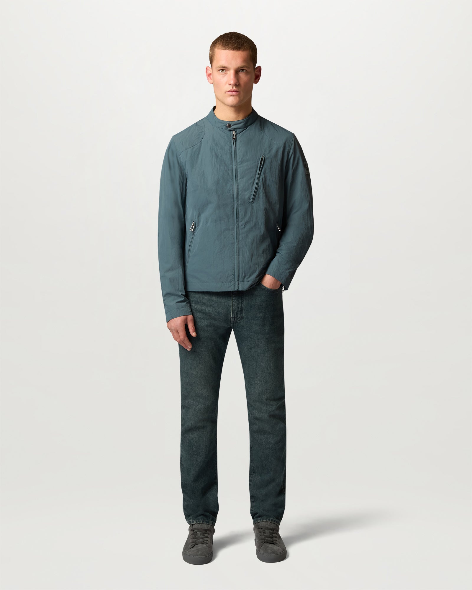 Male model wearing a teal blue lightweight CHASE JACKET with a full front zipper and diagonal chest pocket.