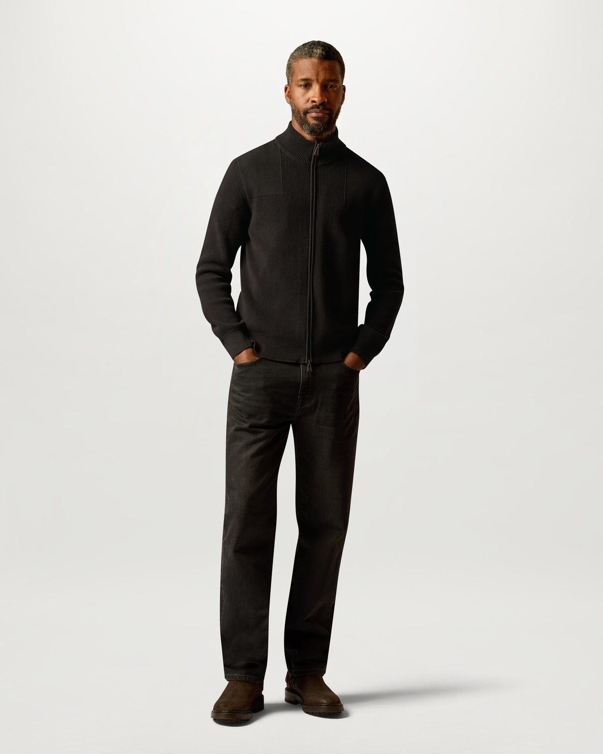Male model wearing black Commander Full Zip cardigan with zip front and ribbed knit.