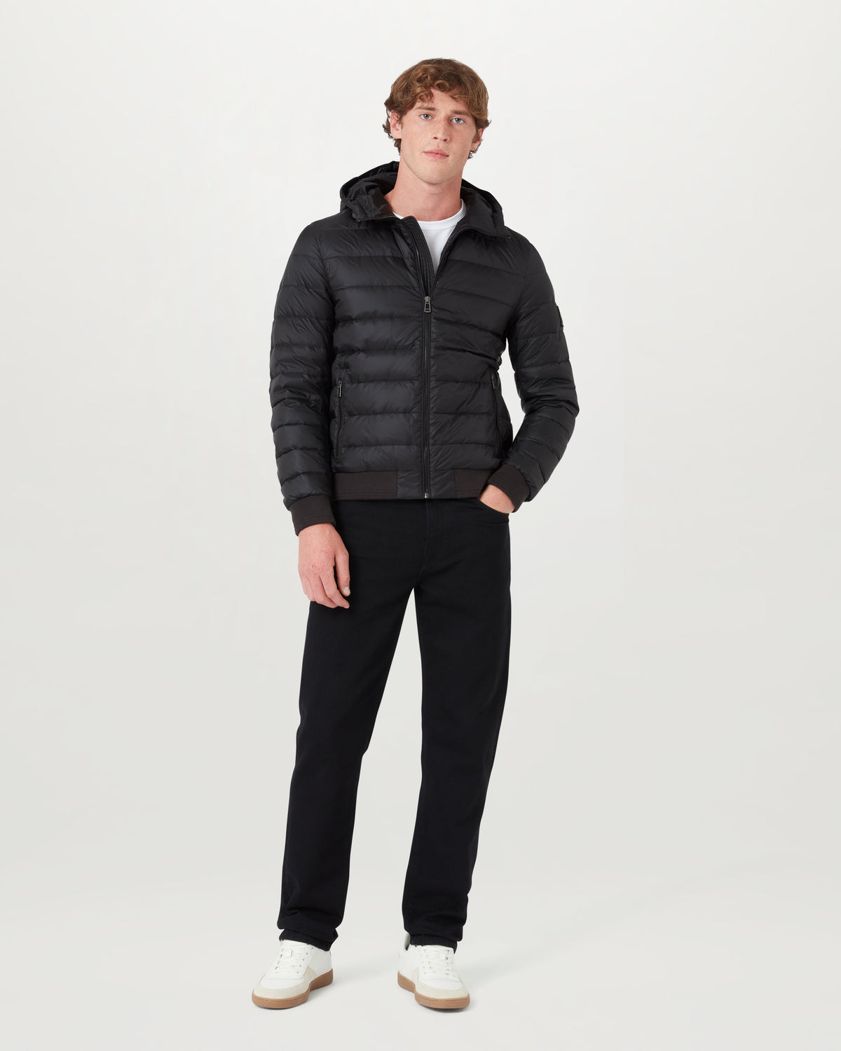 Male model in black Control Jacket with hood down zip closure and ribbed cuffs against a light backdrop