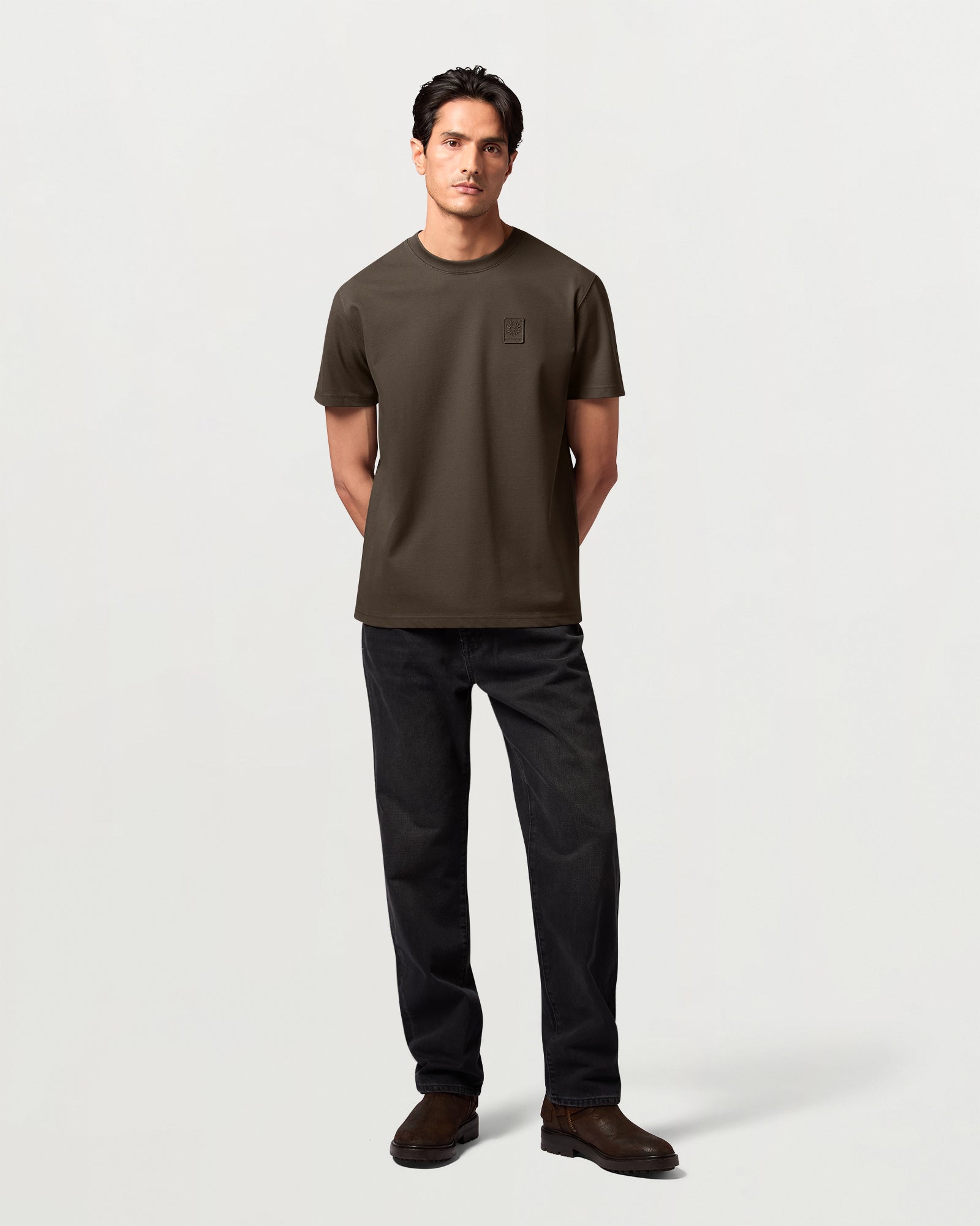 Male model wearing Army Olive Curator Pique T-shirt with a small chest logo.