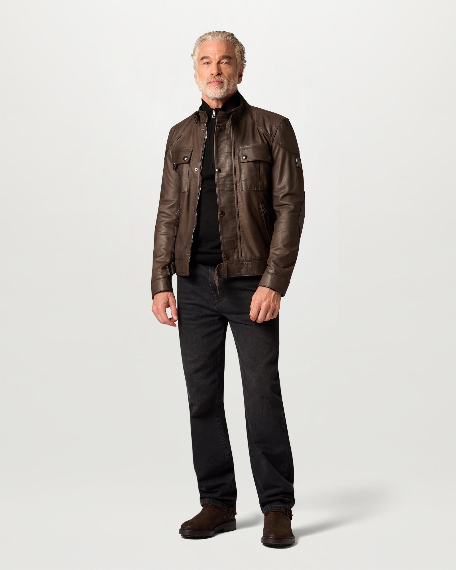 Male model wearing brown Gangster Icon leather jacket with chest bellows pockets and a buckled collar.