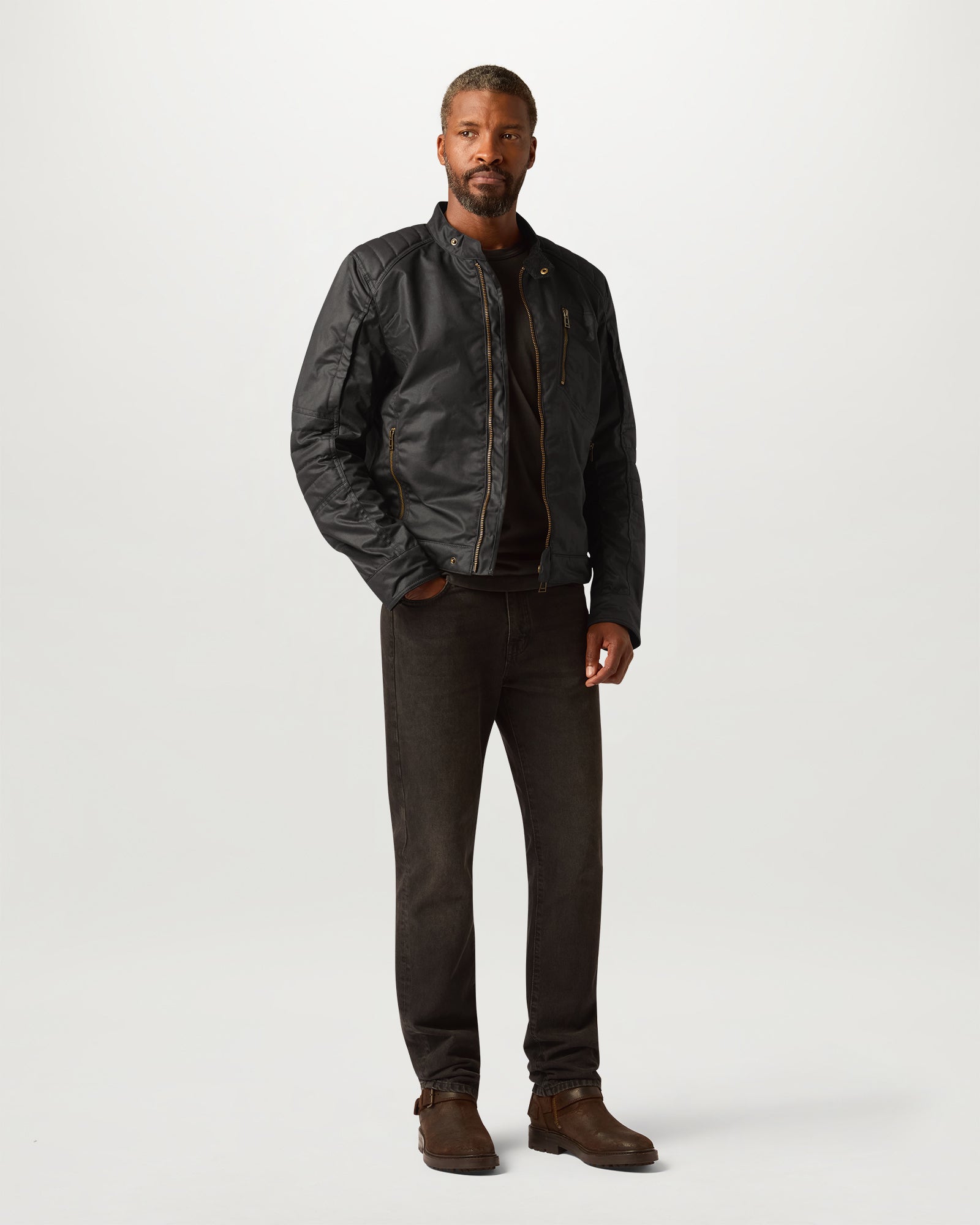 Male model wearing Belstaff Humber Motorcycle Jacket in black with brass zippers against a light backdrop.