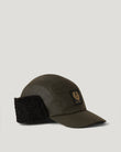 Moorby cap in faded olive waxed cotton with faux fur ear flaps worn by model.