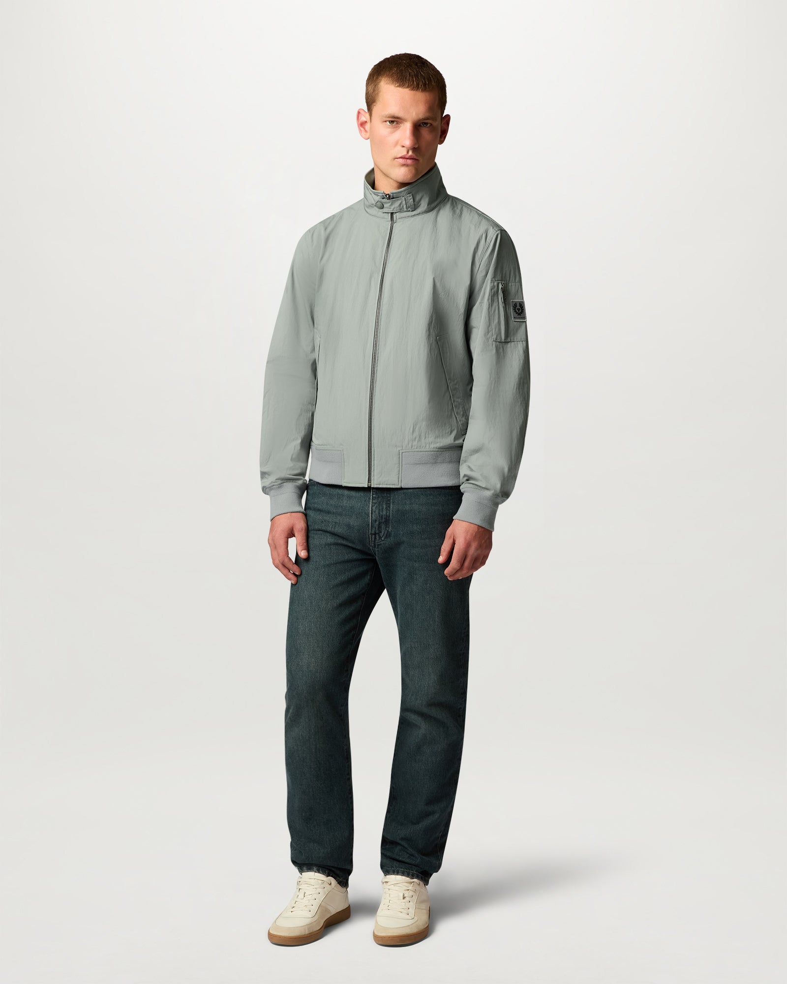 Model wearing Atlantic grey Overland jacket with zip front left sleeve patch and ribbed cuffs