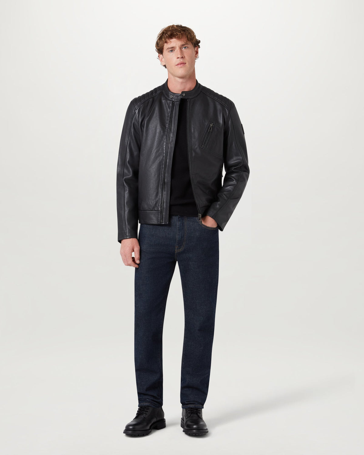 Male model wearing black V Racer leather jacket with zip front and chest pocket paired with dark jeans